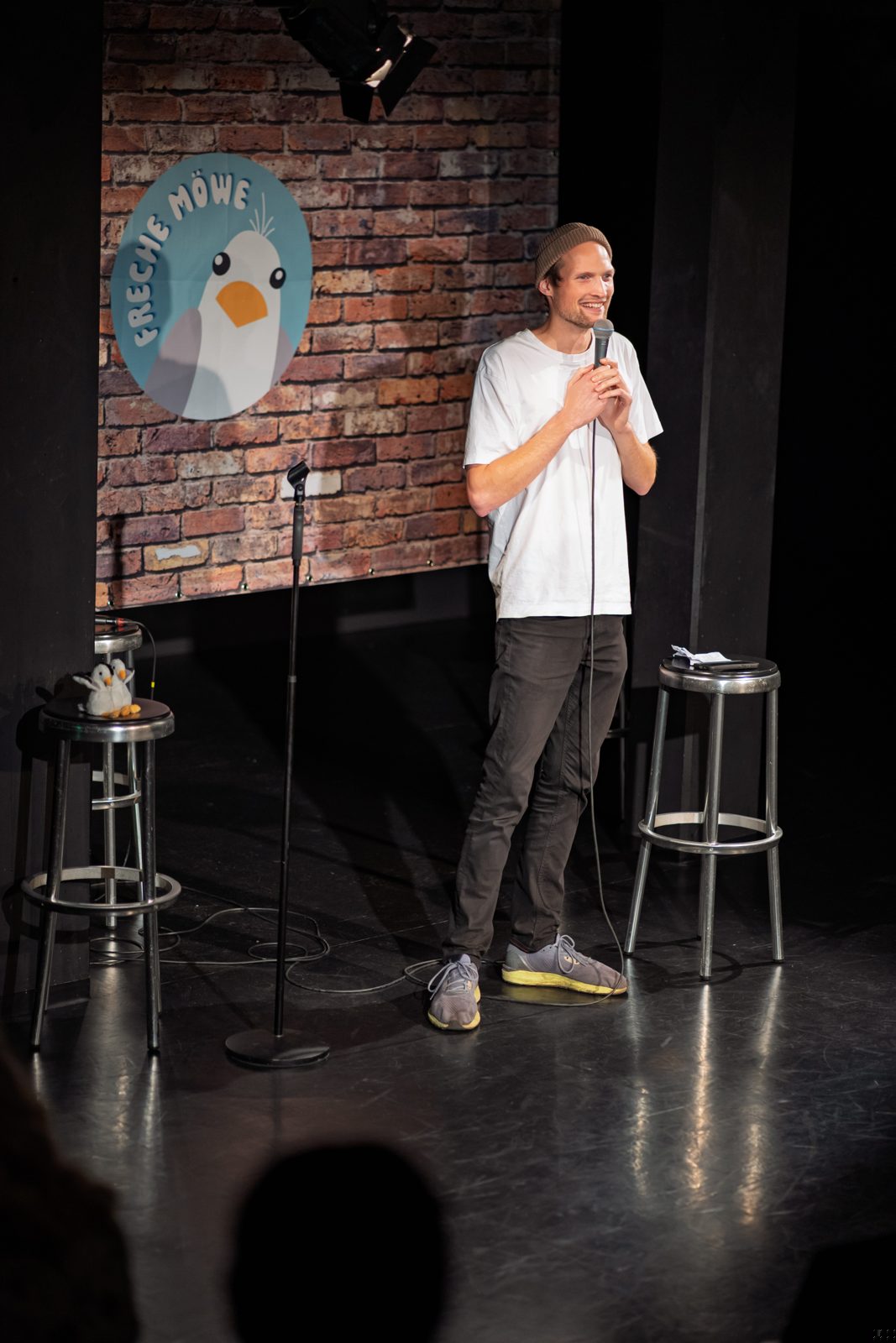 Comedian mit erhobenem Arm auf der Bühne